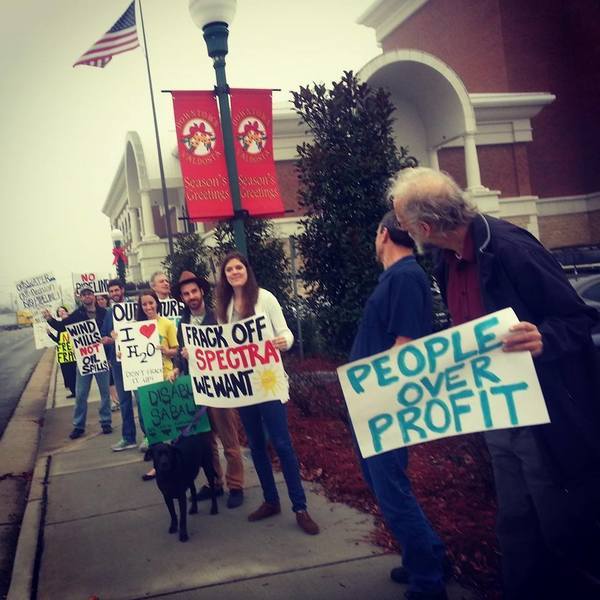 No Fracking; We Cant Drink Money (Andi Ray Drake), in My fellow protesters and me at the spectra energy commissioner's meeting, by Mary Booker, for Lowndes Area Knowledge Exchange, 9 December 2013