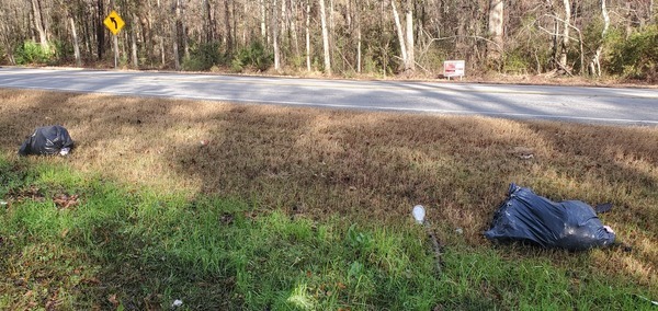 [Trash bags across GA 122 from the rezoning notice sign]